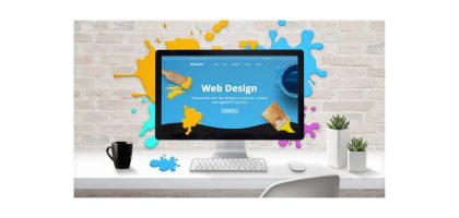 Desktop computer showing web design interface on a creative workspace.