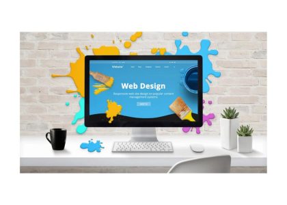 Desktop computer showing web design interface on a creative workspace.